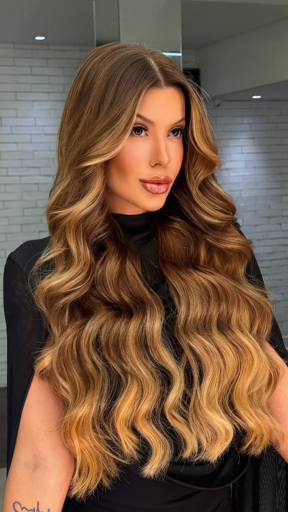 Frantchêsca Antunes em close com o cabelo longo recém-tratado em salão, cor caramelo com mechas douradas.