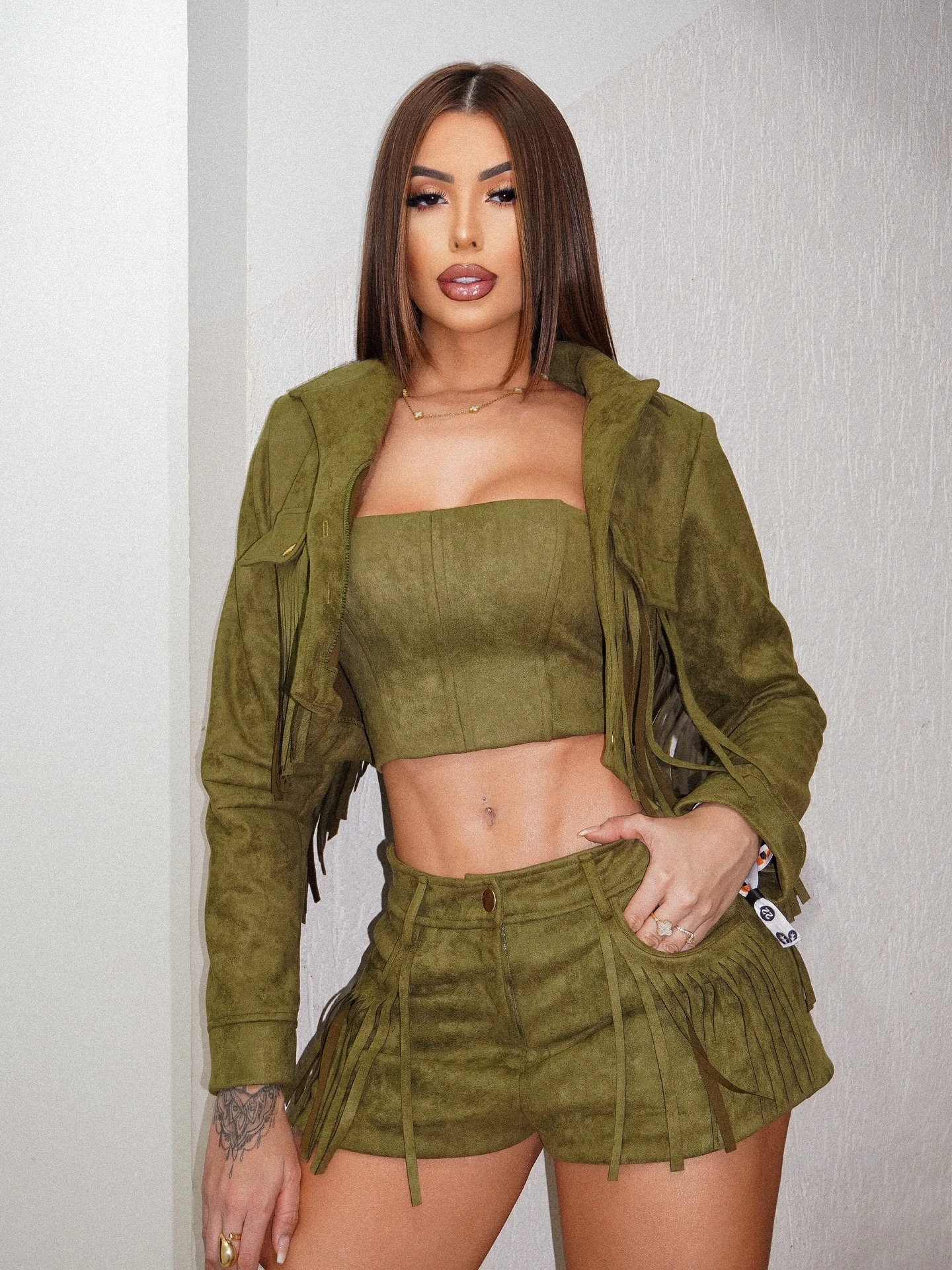 Frantchêsca Antunes de conjunto verde-oliva com franjas, em campanha da marca Stellara Concept.