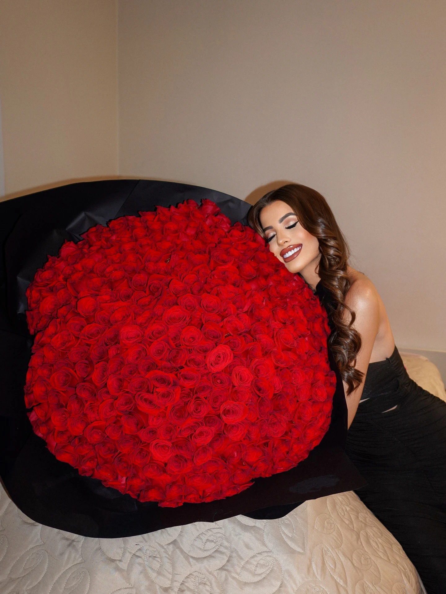 Frantchêsca Antunes sorrindo, abraçada a um grande buquê de rosas vermelhas.
